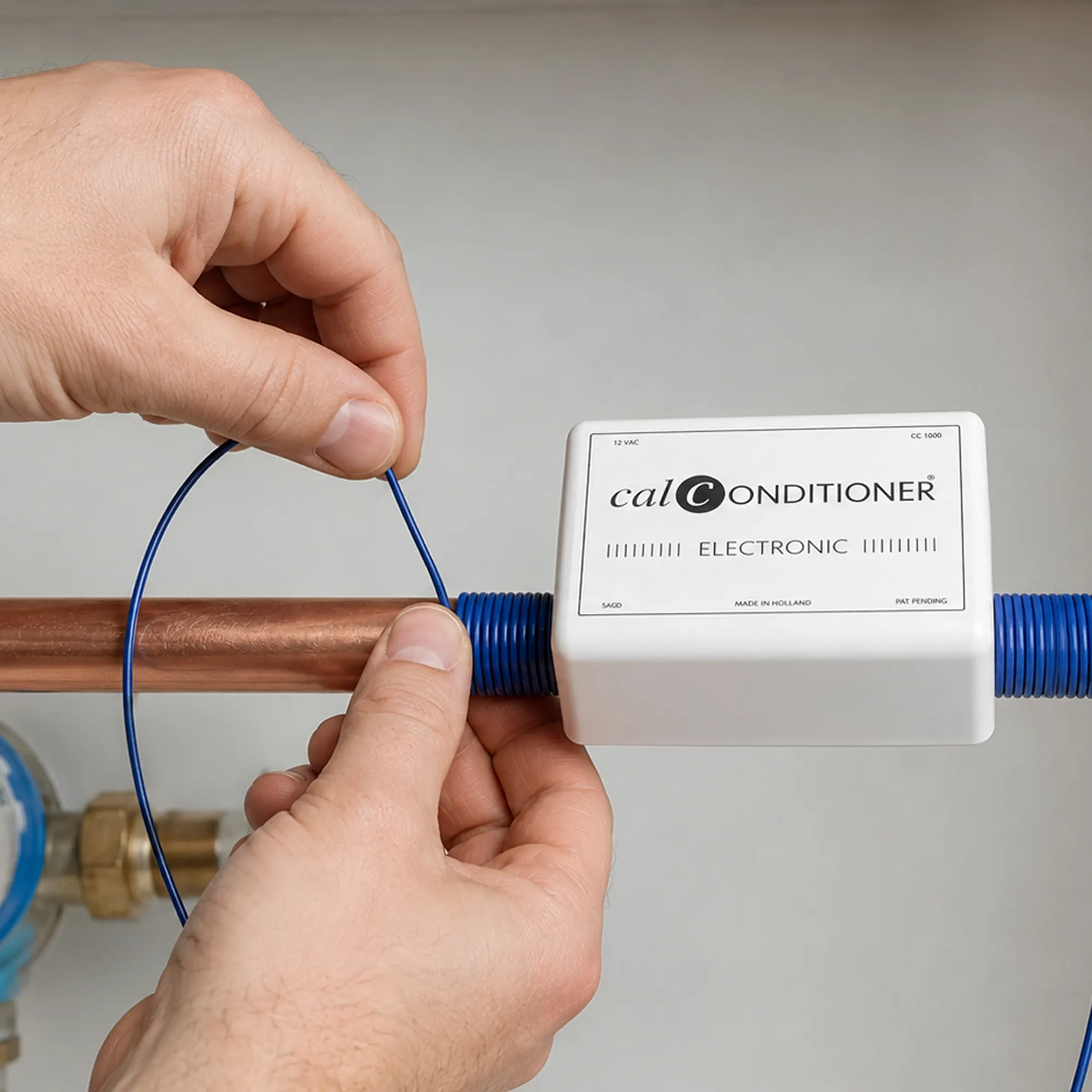 Blauwe spoelkabel van de Calconditioner om een waterleiding wikkelen